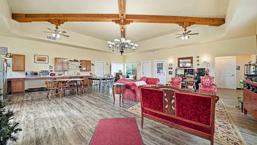 A large open living room with a dining area and kitchen in the background.