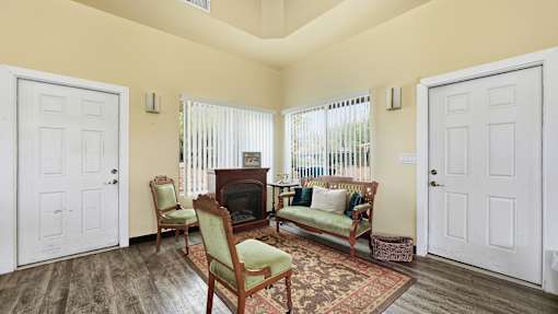 A living room with a fireplace and two chairs.