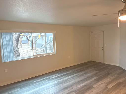 A room with a large window and a wooden floor.