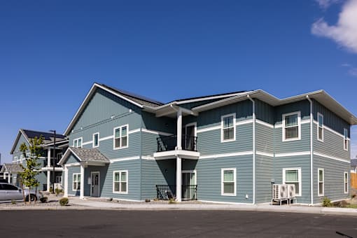 a large blue house with a street in front of it