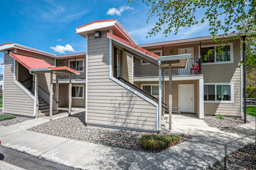an exterior view of a building with stairs and a driveway