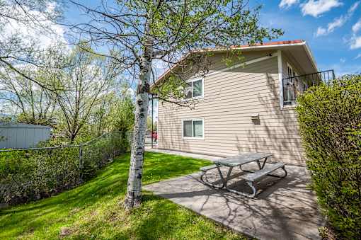 a picnic table on a patio in front of a house