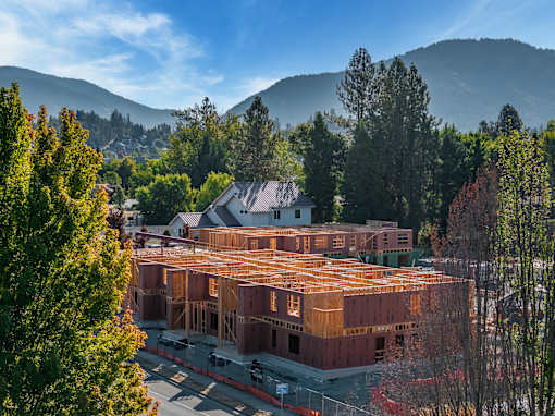 A large building under construction surrounded by trees.