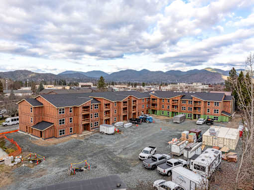 A large building complex with a parking lot in front of it.