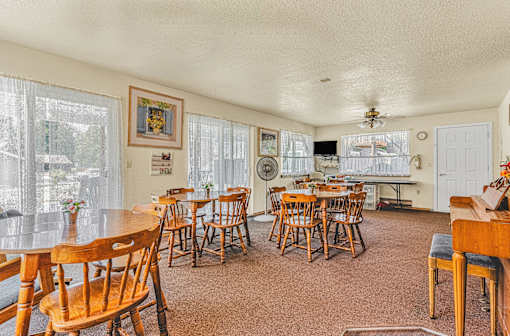 a dining room with tables and chairs and a kitchen