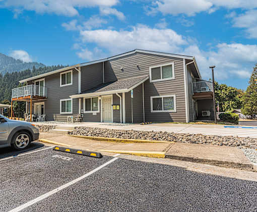 a house with a parking lot and a car parked in front of it