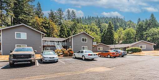 a parking lot filled with cars in front of houses