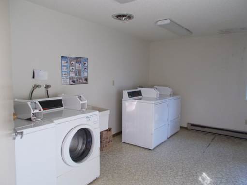 A white washing machine and dryer in a small room.