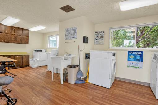 a kitchen with two refrigerators and a sink in a room with a wood floor