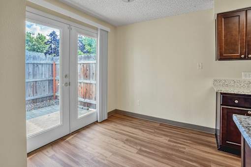 an empty living room with sliding glass doors to a patio