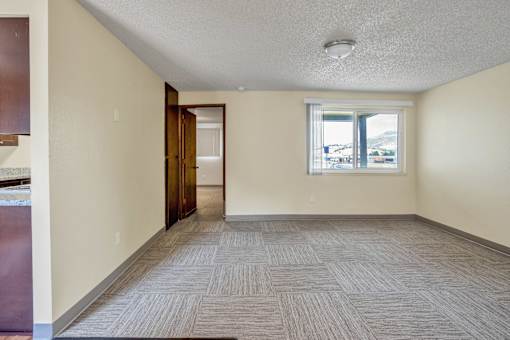 the living room and dining room of an empty house with a window