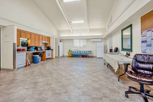 a living room with a kitchen and a table and chairs