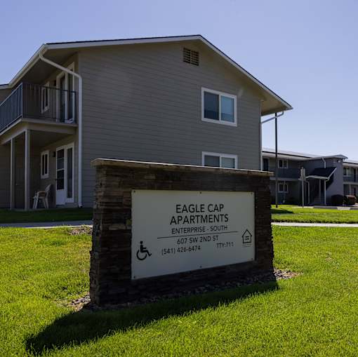an eagle cap apartments sign in front of a house