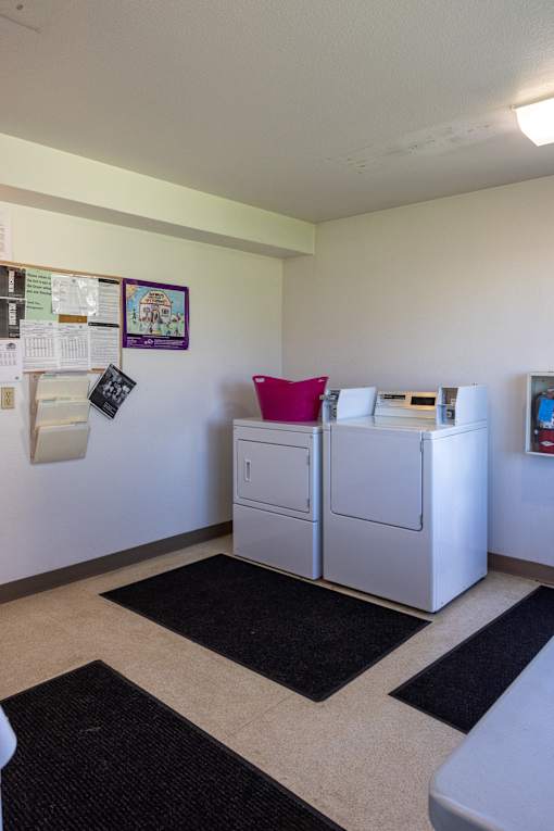 a laundry room with two washers and a dryer in it