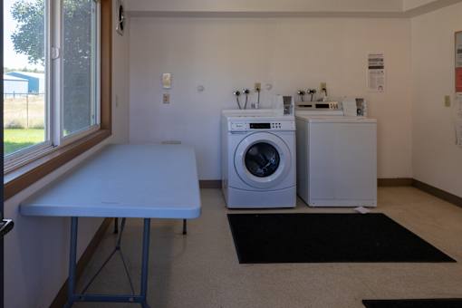 a kitchen with a washing machine and a table and a window