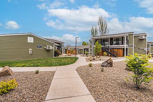 A residential area with a gravel pathway and a few trees.