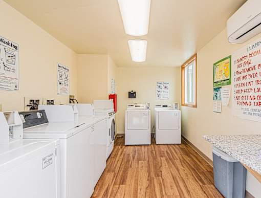 A laundry room with washers and dryers and a sign on the wall.