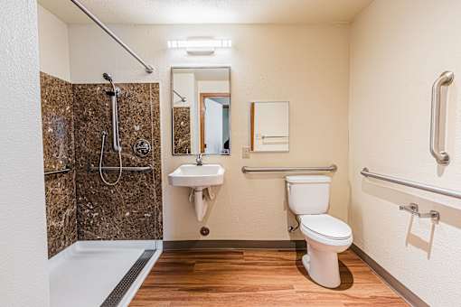 A bathroom with a toilet, sink, and shower.