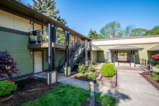 A sunny day at a residential building with a green lawn and a clear blue sky.
