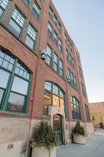 A red brick building with green trim and windows.
