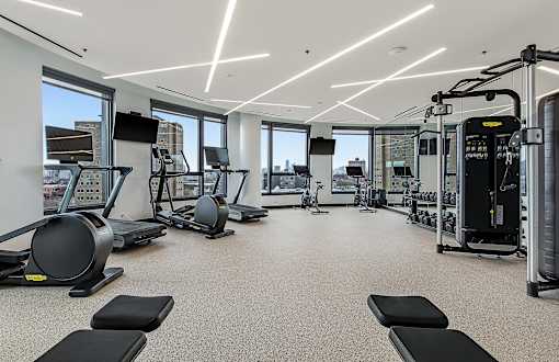 A spacious gym with treadmills, elliptical machines, and other exercise equipment.