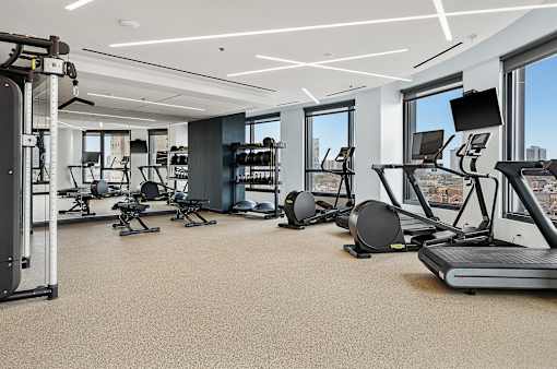 A spacious gym with a variety of equipment including treadmills, weights, and exercise machines.