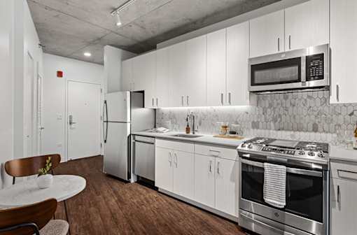 a kitchen with white cabinets and stainless steel appliances