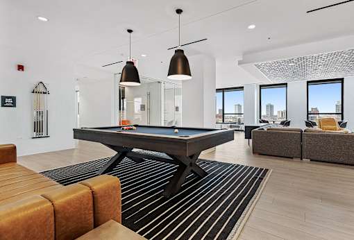 a living room with a pool table in the middle of it