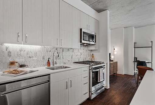 a kitchen with white cabinets and stainless steel appliances