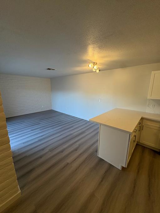A kitchen with a wooden floor and white cabinets.