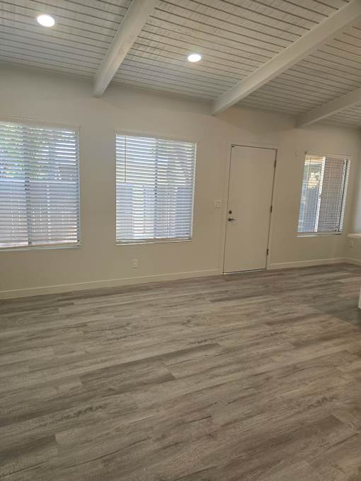 A room with wooden flooring and a white ceiling.