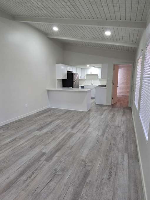 A room with a white counter and a wooden floor.