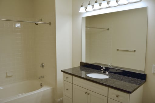 bathroom with large mirror and white finisehs