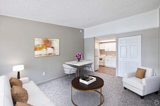 A living room with a white couch, a coffee table, and a painting on the wall.
