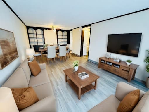 A living room with a brown sofa, a wooden coffee table, and a television.
