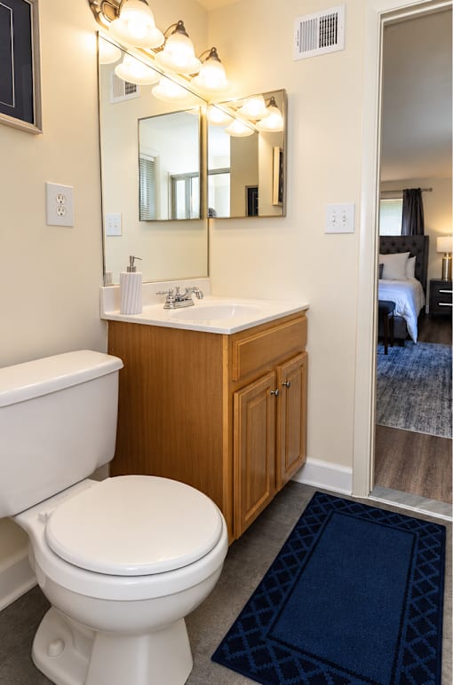 A white toilet sits in a bathroom next to a bathtub