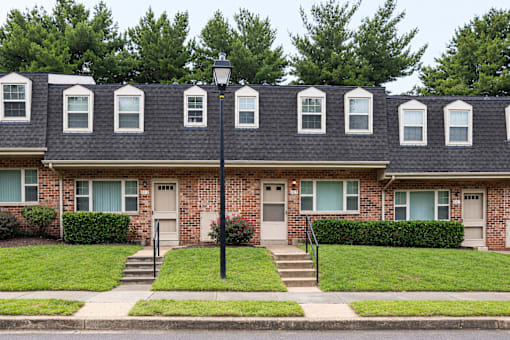 A row of houses with green bushes in front.