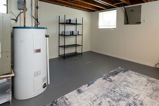 Basement with water heater and a window.