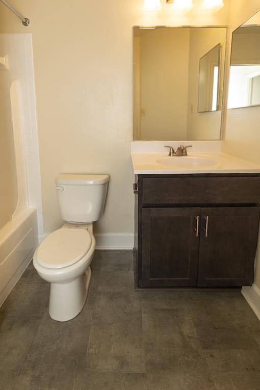 A white toilet sits next to a sink in a bathroom at Lawyers Hill Apartments, Elkridge, 21075