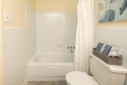 A white bathroom with a tub, toilet and sink.