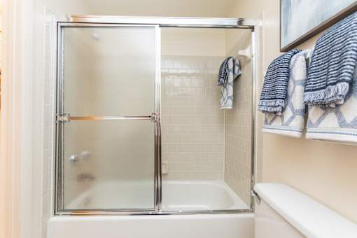 A small white bathroom with a glass shower door.