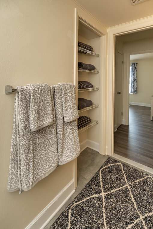 A bathroom with a towel rack and a rug at The Brittany Apartments, Pikesville, MD