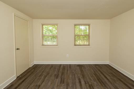 A room with wooden floors and two windows at The Orchards at Severn Townhomes*, Severn, MD 21144