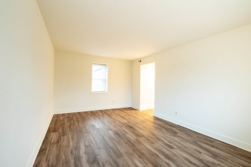 a bedroom with hardwood floors and white walls  at Charlesgate Apartments, Towson, Maryland