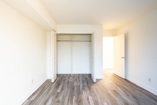 an empty bedroom with white walls and wood floors  at Charlesgate Apartments, Towson, 21204
