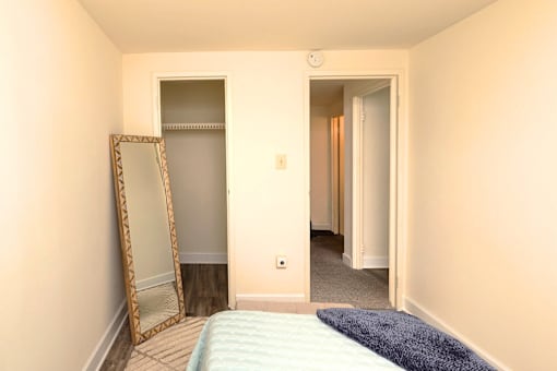 A bedroom with a bed, mirror and wardrobe at Kingston Townhomes, Baltimore, MD