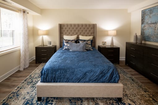 Bedroom with a bed and dressers at Ivy Hall Apartments*, Towson, MD 21204.