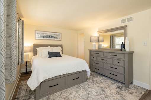 Primary bedroom with bed and dresser with mirror
