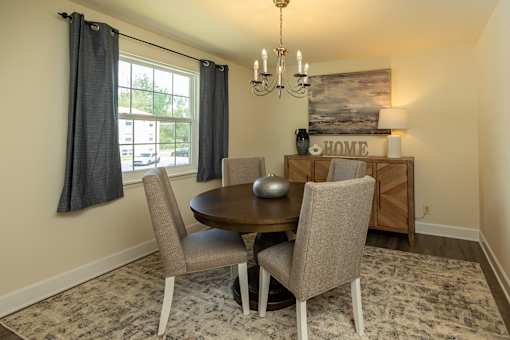 A dining room with a round table and chairs at The Brittany Apartments, Pikesville, MD