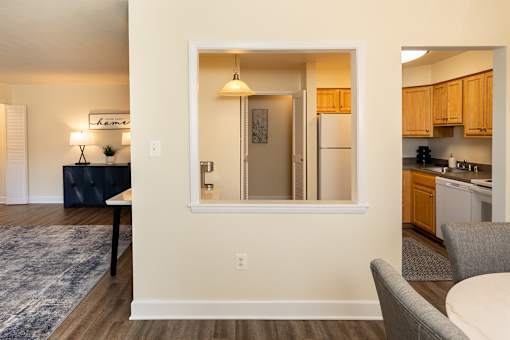 A kitchen area with a fridge, a table, and a couch.
